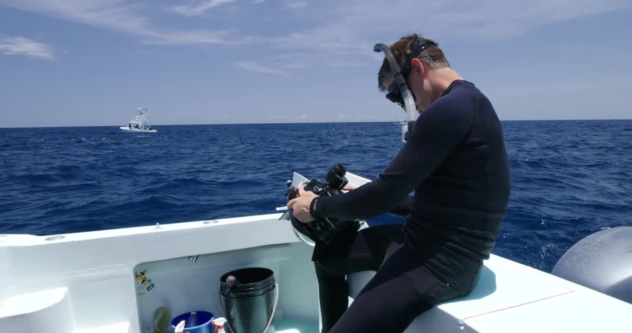 A man sitting on a boat looking at a camera