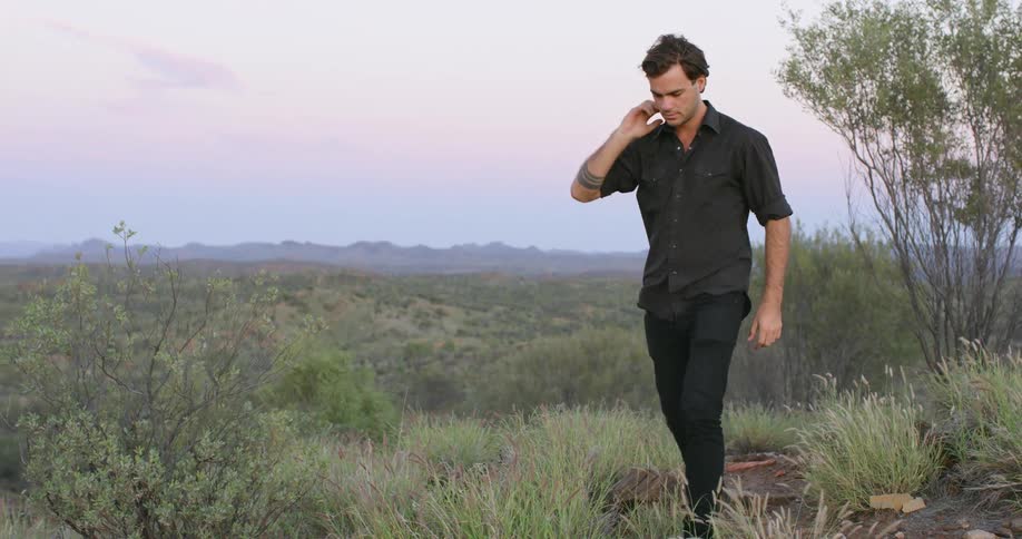 A man is walking in the wilderness with his dog