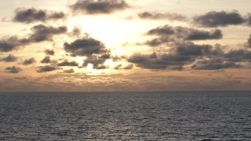 Waves roll in the ocean as the sun sets