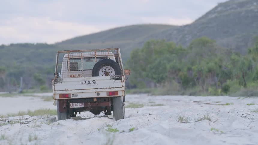 A vehicle is traveling in the sand