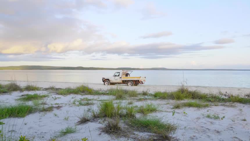 A man driving his truck down the beach