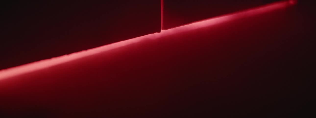 Red light and smoke shine out from under the door