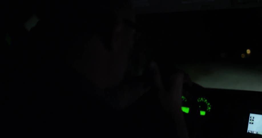 A man is driving a vehicle at night and we can see the dashboard