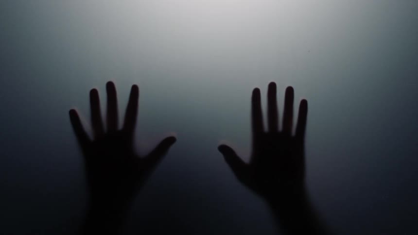 Silhouetted hands run down a sheet