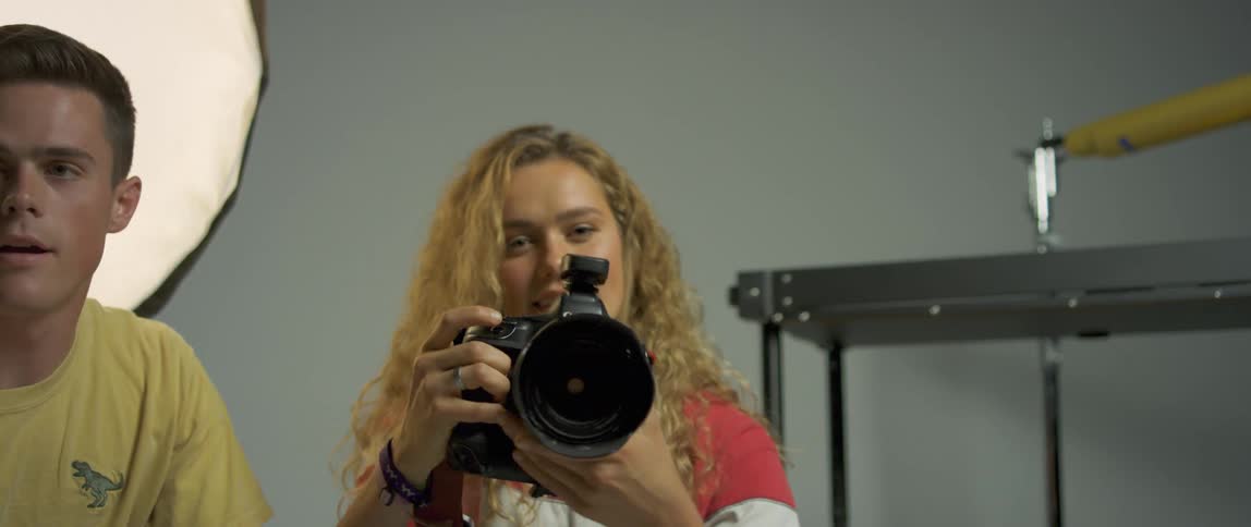 A woman is taking photographs in a studio