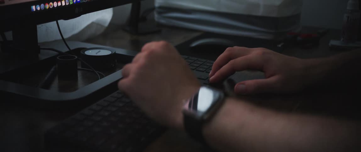 A man is sitting at a desk and using a computer