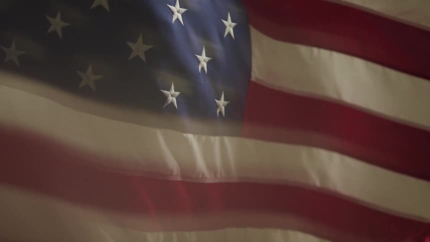 Close up of the american flag half blurred fluttering in the wind