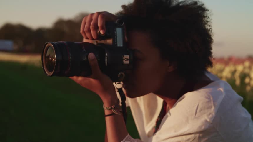 A woman taking photos in a field
