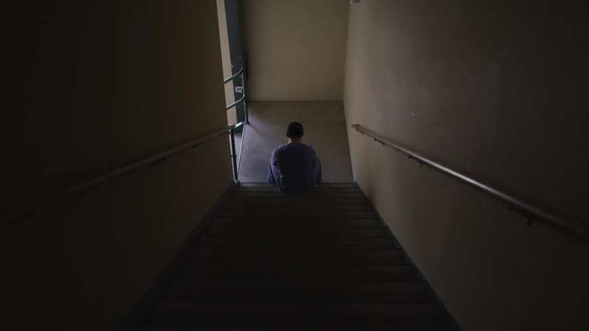 A nurse sits in a stairwell