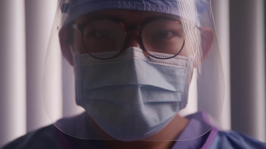 Close up of a doctor face wearing face mask and protective gear