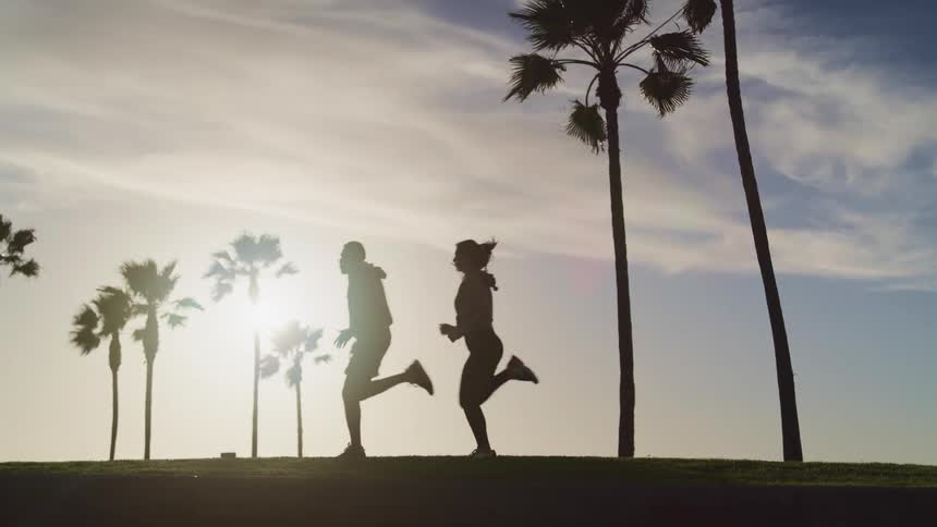A man and woman running outside