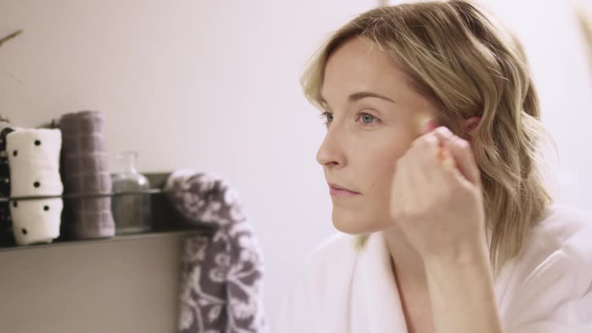 A woman putting make up on