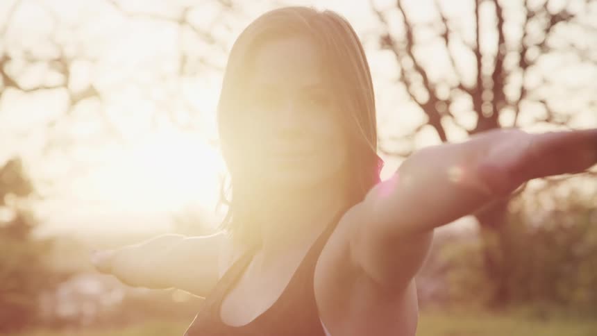 A young woman practices yoga outside