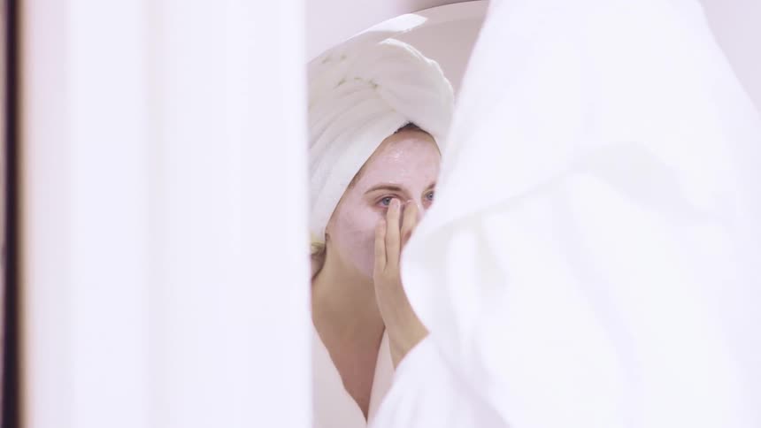 A teenager putting a mask on her face