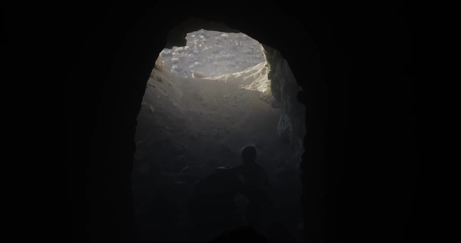 A man carries a child out of a cave