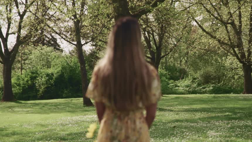 A teenage girl looks at the trees ahead of her