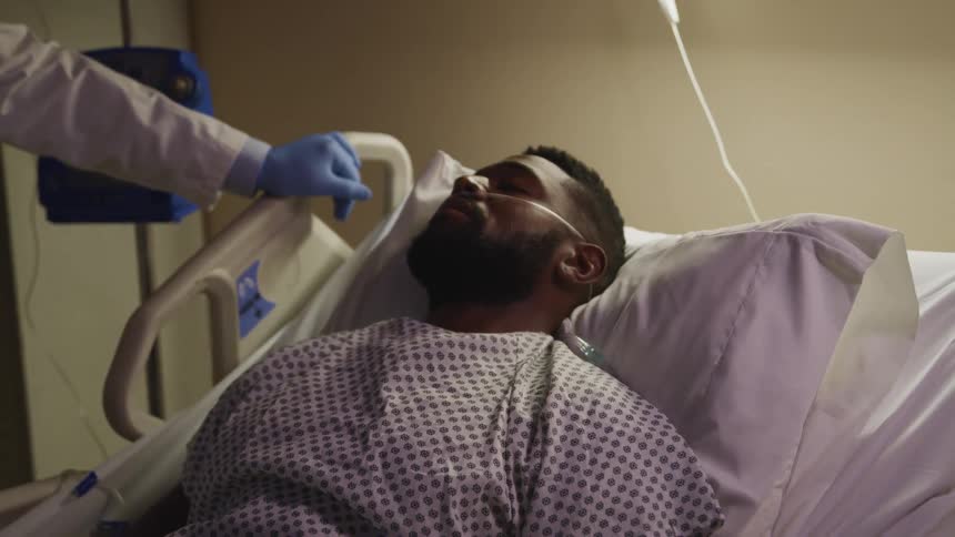 A black male on a hospital bed near a doctor