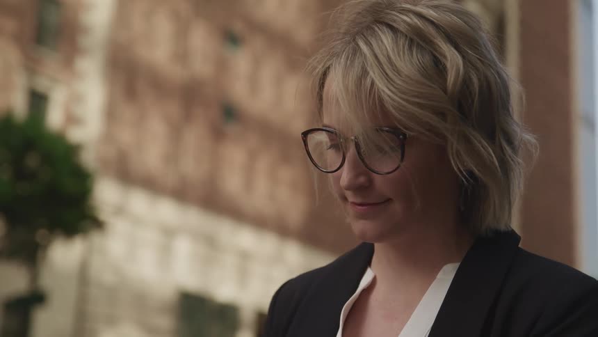 A woman is smiling and looking down