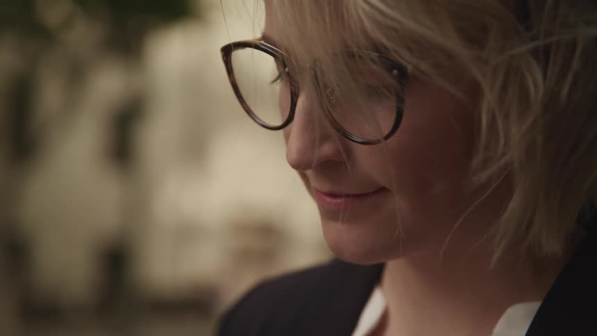 A woman looks down and smiles