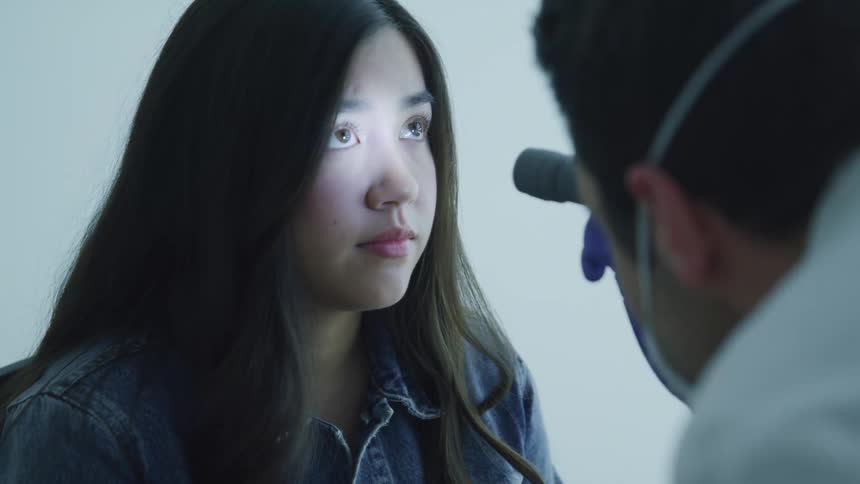 A doctor examines a girls eyes