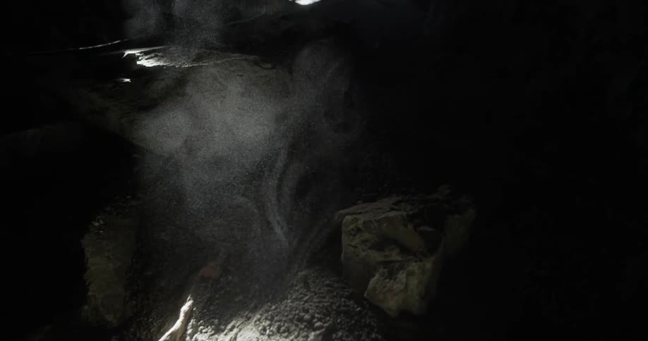 Dust swirls around in the sunlight in a dark room