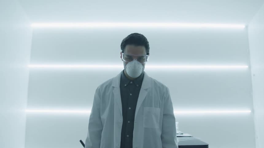 A person looks up wearing a lab coat