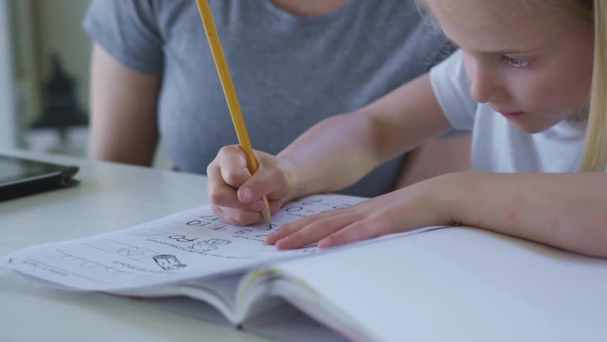 A child is doing homework on the table