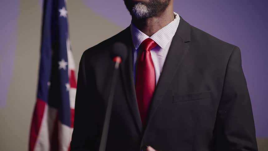 A politician moves his hands as he speaks during a news conference