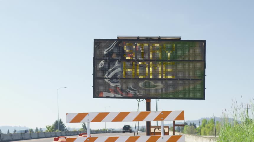 Vehicles travel on the highway past a sign