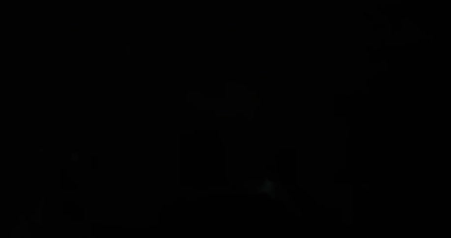 People are using a flashlight to search a dark cave