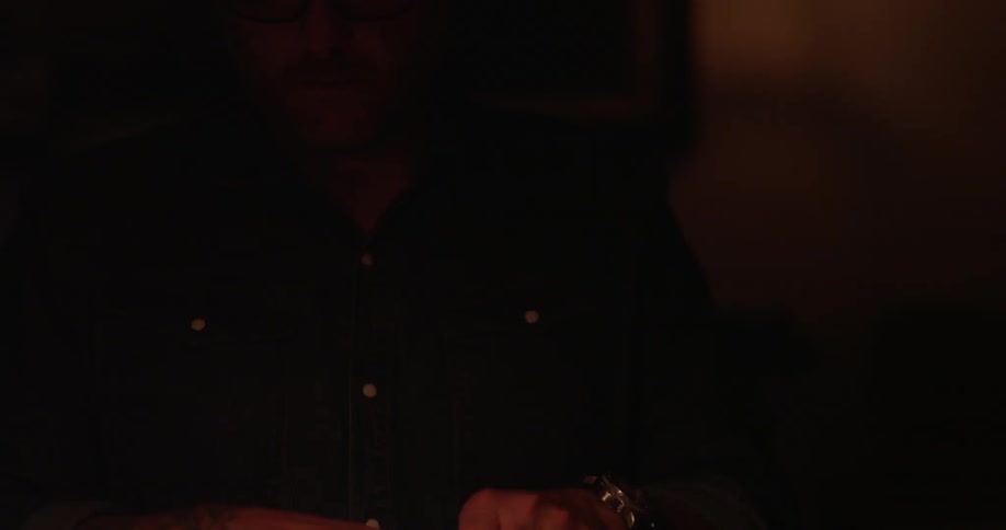 A man closes up a book on a desk