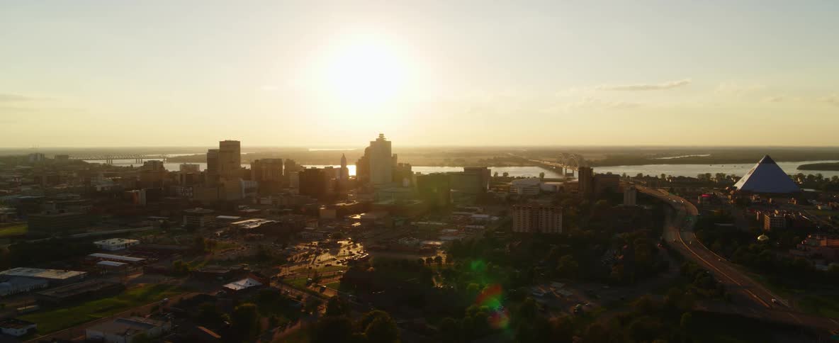 Sun shines across bridge spanned river and city downtown