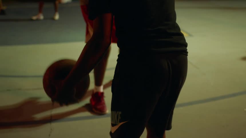 People are playing a game of basketball at night