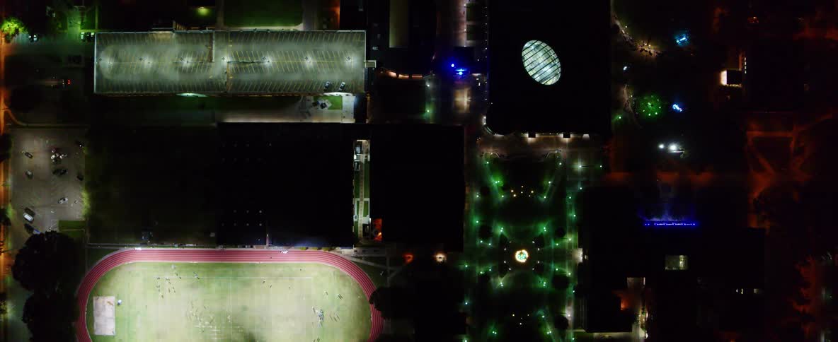 An aerial view of a downtown city is displayed at night