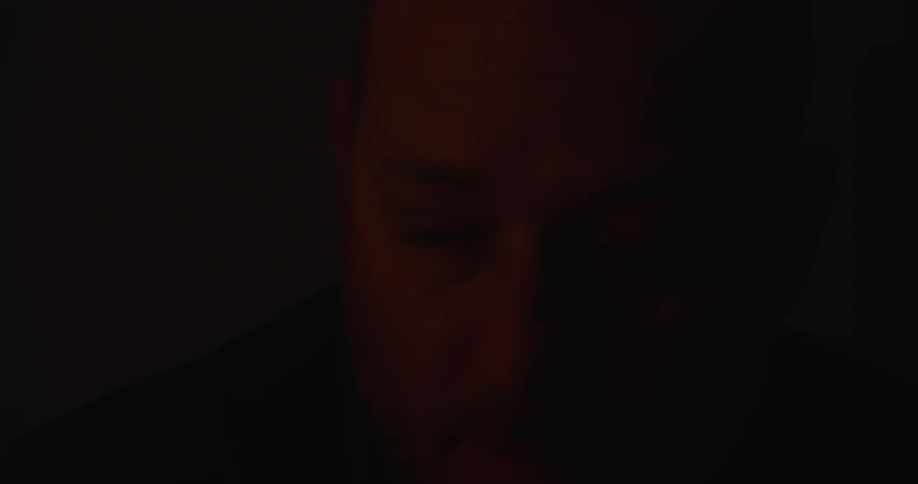 Man wakes and sits up before putting on glasses