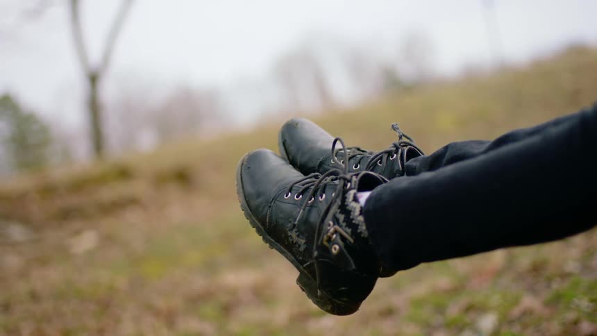 A person with her legs stretched out above the grass