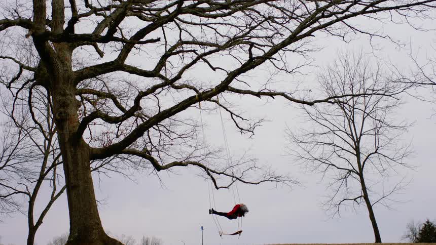 A person is laying in a swing