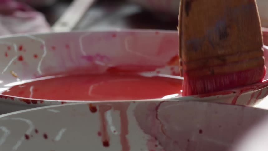 Paint is being mixed with a paint brush