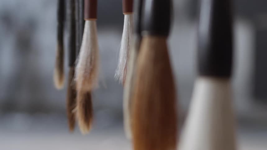 Paint brushes hanging and swinging in the air