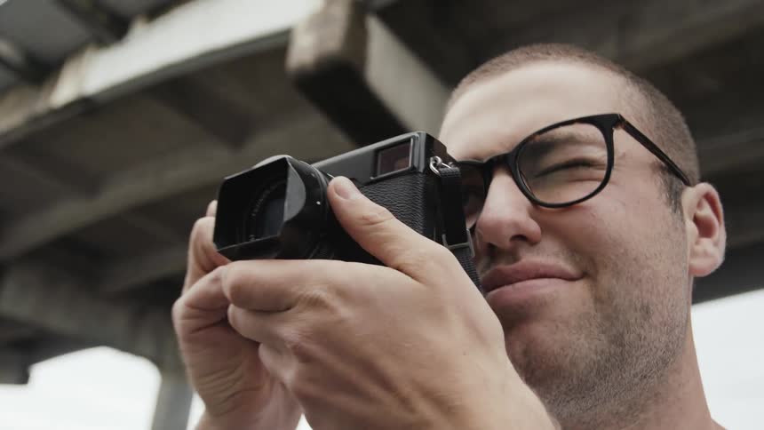 Man taking a picture outdoors with a hand held camera