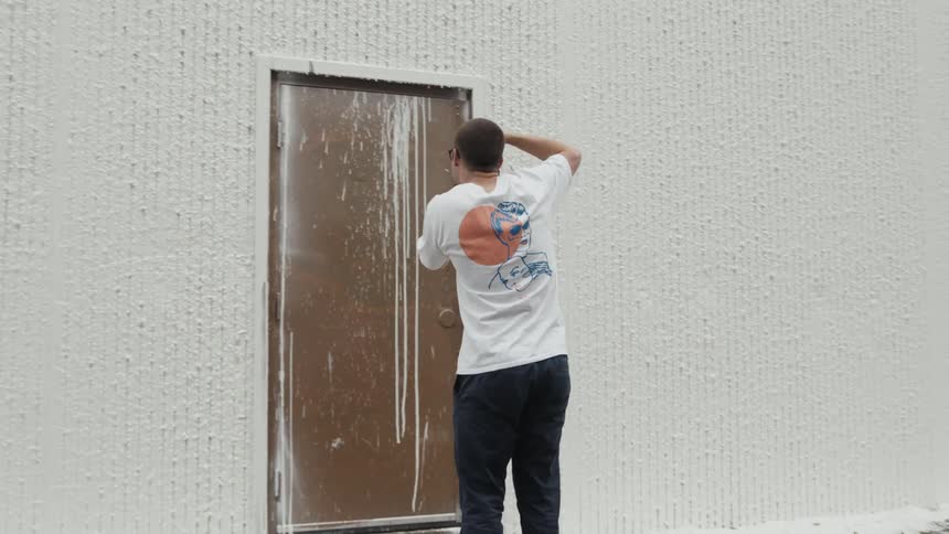 A male photographer taking photos of a messy painted door