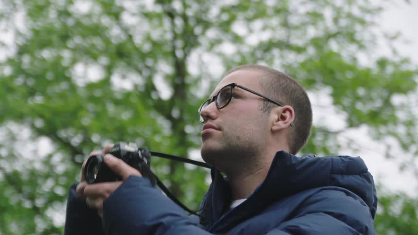 A man is taking photos outdoors of nature
