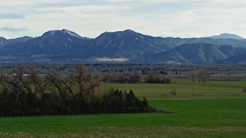 Blue mountains are shown on the horizon with trees and vegetation