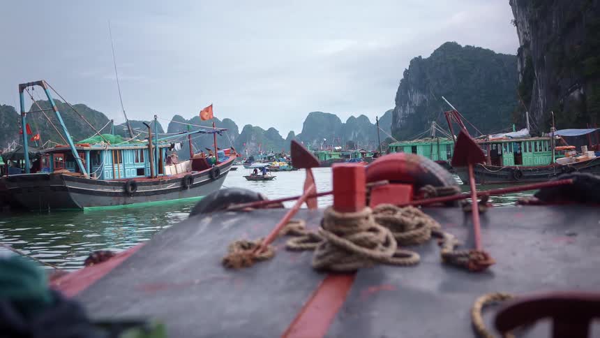 Boats in the water with cliffs the sky and clouds in the background