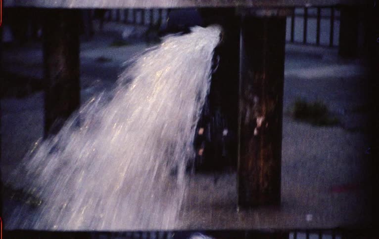Fire hydrant leaking water onto the street in a downtown city neighborhood