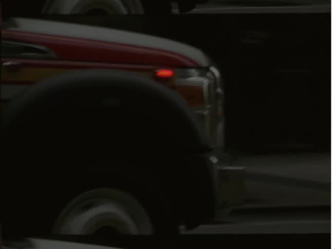 An ambulance travels down the street of a metropolis with its sirens flashing