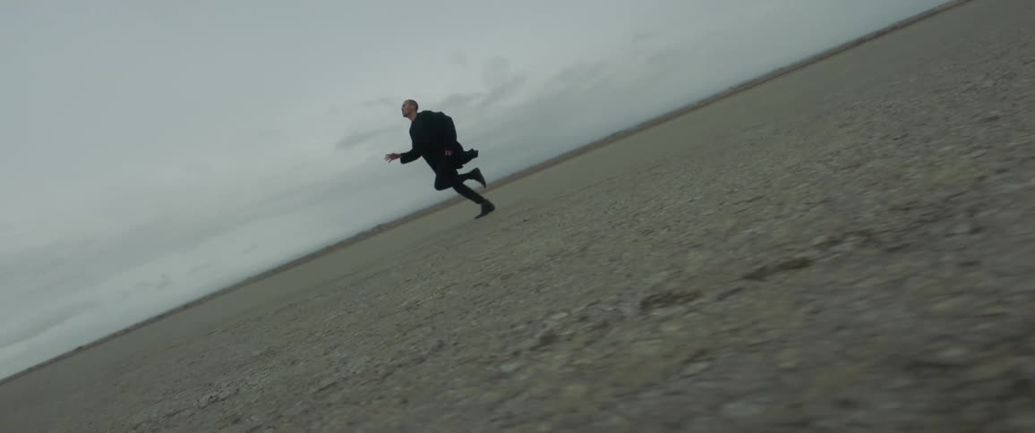 A man runs across a dirt field