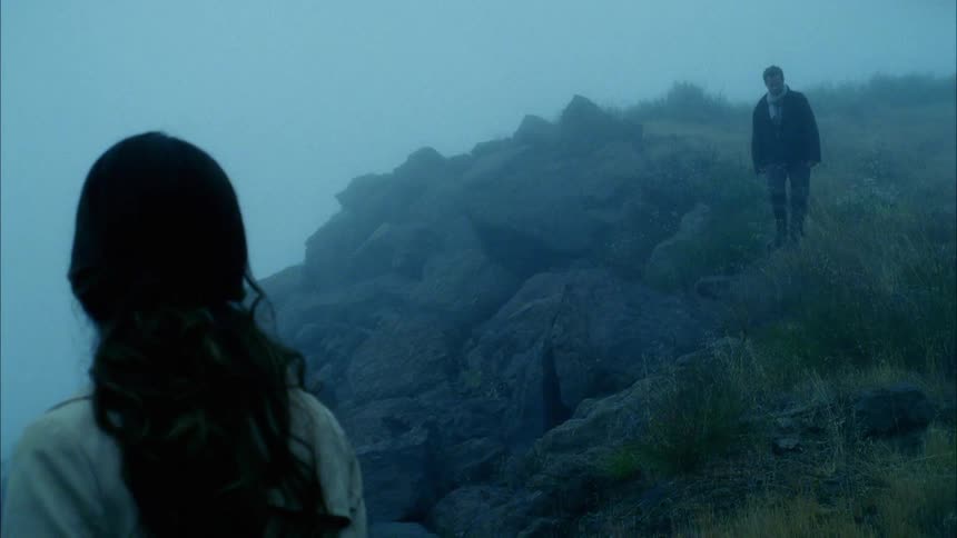 Man descends a hill as a woman watches