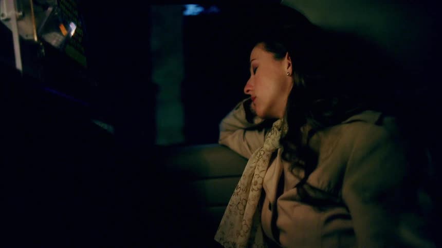 A woman is a passenger in a car while driving through a city