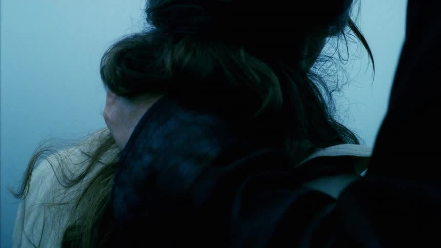 A man with his arm around a woman kisses her head